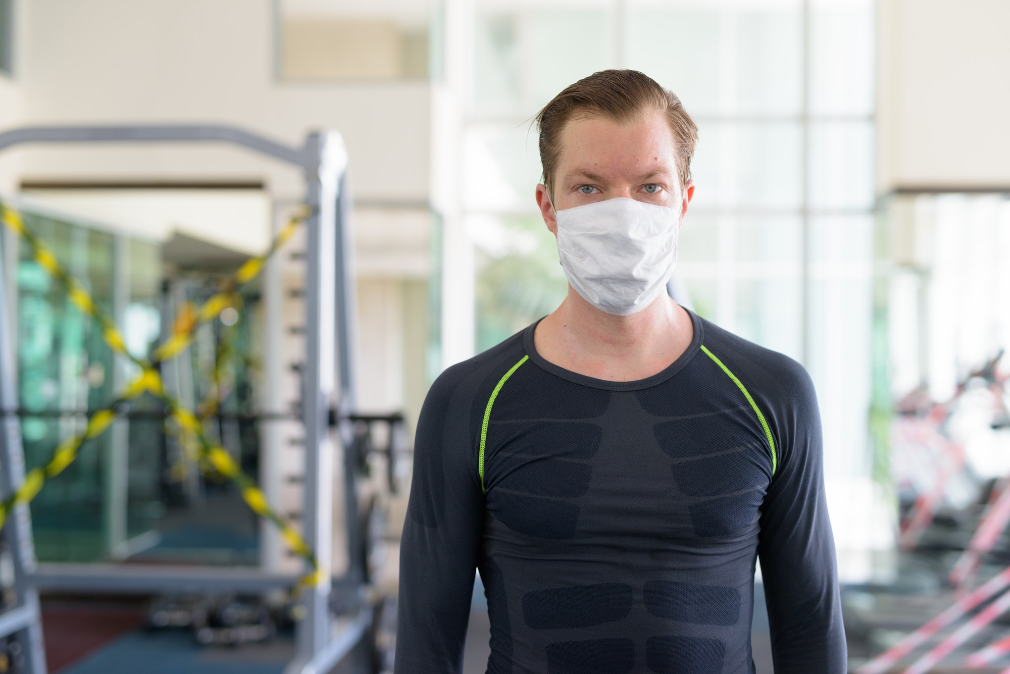 Young man with mask for protection from corona virus outbreak at gym during corona virus covid-19